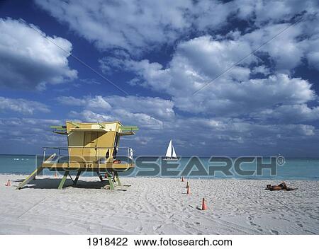 Man Sunbathing Beside Lifeguards Tower On South Beach As Yacht Goes By In The Background, Miami View Large Photo Image Stock Image - Man Sunbathing Beside Lifeguards Tower On South Beach As Yacht Goes By In The Background, Miami. Fotosearch