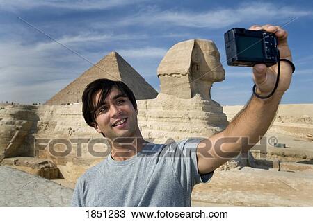 Stock Image - Man Taking A Picture Of Himself With Sphinx In Background. Fotosearch
