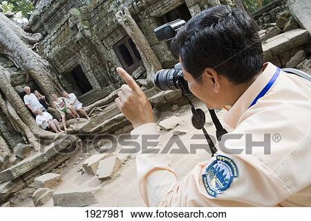 Man Taking Photo Group Of People At Temple Of Ta Prohm,, Siem Reap, Cambodia View Large Photo Image Stock Image - Man Taking Photo Group Of People At Temple Of Ta Prohm,, Siem Reap, Cambodia. Fotosearch