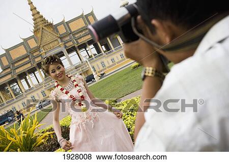 Stock Photo - Man Taking Picture Young Woman Front Of Royal Palace, Phnom Penh, Cambodia. Fotosearch