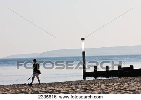 Man Using Metal Detector On Beach; Bournemouth, Dorset, England View Large Photo Image Stock Photograph - Man Using Metal Detector On Beach; Bournemouth, Dorset, England. Fotosearch