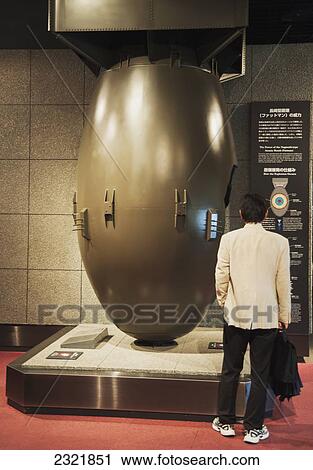 Stock Image - Man visiting exhibition at Atomic Bomb Museum; Nagasaki, Japan. Fotosearch