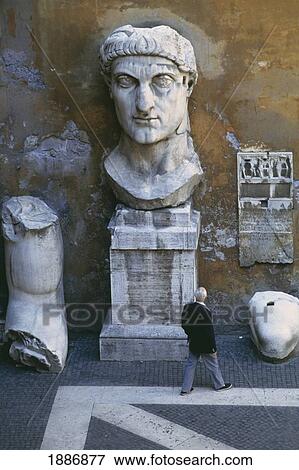 Stock Photo - Man Walking By Statues At Courtyard Of Palazzo Dei Conservatori. Fotosearch
