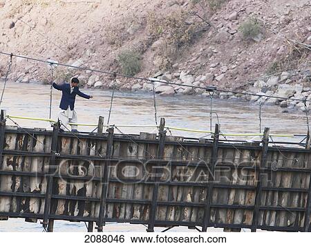 Man Walking On A Collapsed Suspension Bridge Over The Jelhum River After The 8 October 2005 Earthquake, Garhi Dopatta, Azad Jammu & Kashmir, Pakistan View Large Photo Image Stock Photograph - Man Walking On A Collapsed Suspension Bridge Over The Jelhum River After The 8 October 2005 Earthquake, Garhi Dopatta, Azad Jammu & Kashmir, Pakistan. Fotosearch