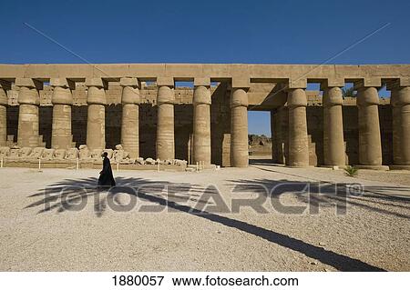 Stock Photo - Man Walking Past Shadow Of Date Palm In Forecourt. Fotosearch