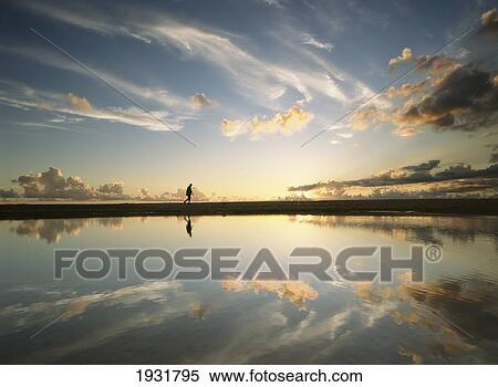 Man Walking Past Shallow Pool Beside Brighton Beach On West Coast Of Barbados At Dusk. View Large Photo Image Stock Photography - Man Walking Past Shallow Pool Beside Brighton Beach On West Coast Of Barbados At Dusk.. Fotosearch