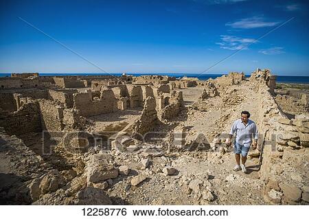 Stock Photograph - Man walking through old fortress near Duba; Saudi Arabia. Fotosearch