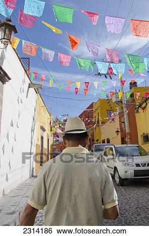 Man walking under colorful street decorations; San Miguel de Allende, Guanajuato, Mexico View Large Photo Image Stock Photograph - Man walking under colorful street decorations; San Miguel de Allende, Guanajuato, Mexico. Fotosearch