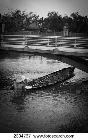 Stock Photo - Man With Rowboat In River; Hue, Vietnam. Fotosearch