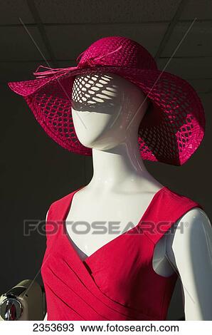 Stock Image - Mannequin wearing a red dress and red hat; England. Fotosearch