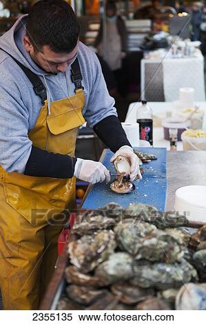 Market vendor at Borough Market preparing oysters for customers; London, England View Large Photo Image Stock Photography - Market vendor at Borough Market preparing oysters for customers; London, England. Fotosearch