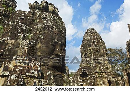 Massive stone faces in 12th century Bayon Temple which is the central temple in Angkor Thom, located north of Angkor Wat; Siem Reap, Cambodia View Large Photo Image Stock Image - Massive stone faces in 12th century Bayon Temple which is the central temple in Angkor Thom, located north of Angkor Wat; Siem Reap, Cambodia. Fotosearch