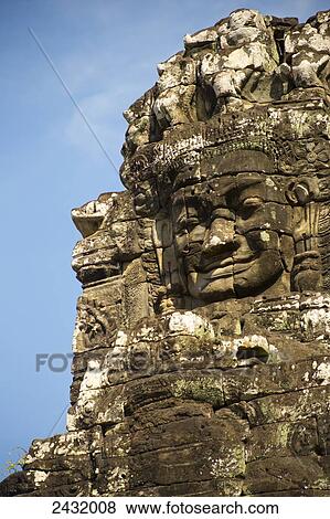Massive stone faces in 12th century Bayon Temple which is the central temple in Angkor Thom, located north of Angkor Wat; Siem Reap, Cambodia View Large Photo Image Stock Photo - Massive stone faces in 12th century Bayon Temple which is the central temple in Angkor Thom, located north of Angkor Wat; Siem Reap, Cambodia. Fotosearch