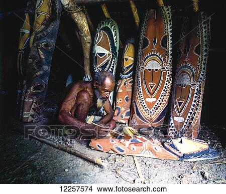 Master carver inside a Maprik Mens house; West Sepik, Papua New Guinea View Large Photo Image Picture - Master carver inside a Maprik Mens house; West Sepik, Papua New Guinea. Fotosearch