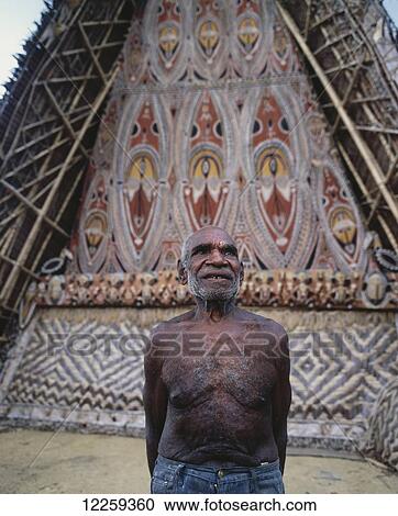 Stock Image - Mastercarver outside a Maprik Mens house; West Sepik Province, Papua New Guinea. Fotosearch