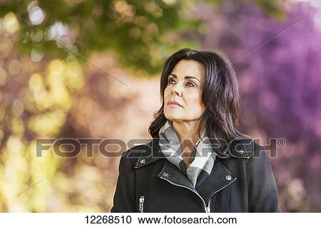 Mature businesswoman walking outdoors in a city park in autumn; Edmonton, Alberta, Canada View Large Photo Image Stock Image - Mature businesswoman walking outdoors in a city park in autumn; Edmonton, Alberta, Canada. Fotosearch