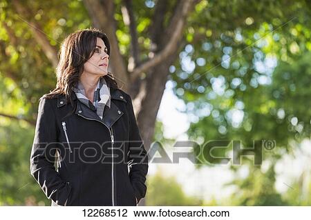 Mature businesswoman walking outdoors in a city park in autumn; Edmonton, Alberta, Canada View Large Photo Image Stock Image - Mature businesswoman walking outdoors in a city park in autumn; Edmonton, Alberta, Canada. Fotosearch