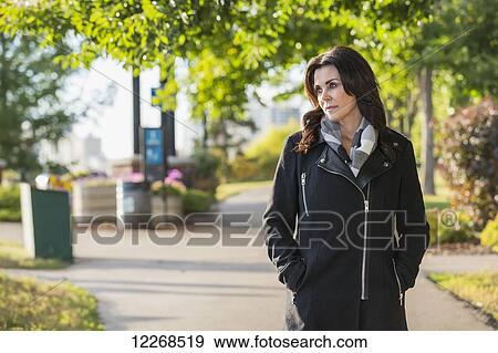 Mature businesswoman walking outdoors in a city park in autumn; Edmonton, Alberta, Canada View Large Photo Image Stock Photo - Mature businesswoman walking outdoors in a city park in autumn; Edmonton, Alberta, Canada. Fotosearch