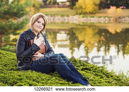 Mature Christian woman embracing her Bible in a park beside a lake in autumn; Edmonton, Alberta, Canada View Large Photo Image Stock Image - Mature Christian woman embracing her Bible in a park beside a lake in autumn; Edmonton, Alberta, Canada. Fotosearch
