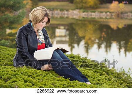 Mature Christian woman reading her Bible in a park beside a lake in autumn; Edmonton, Alberta, Canada View Large Photo Image Stock Image - Mature Christian woman reading her Bible in a park beside a lake in autumn; Edmonton, Alberta, Canada. Fotosearch