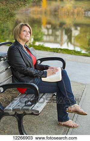 Mature Christian woman studying her Bible in a city park setting beside a lake; Edmonton, Alberta, Canada View Large Photo Image Stock Image - Mature Christian woman studying her Bible in a city park setting beside a lake; Edmonton, Alberta, Canada. Fotosearch