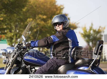 Mature man wearing a helmet on a motorcycle; Edmonton, Alberta, Canada View Large Photo Image Stock Photograph - Mature man wearing a helmet on a motorcycle; Edmonton, Alberta, Canada. Fotosearch