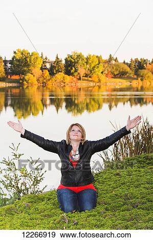 Mature woman with arms raised in worship beside lake in autumn; Edmonton, Alberta, Canada View Large Photo Image Stock Photo - Mature woman with arms raised in worship beside lake in autumn; Edmonton, Alberta, Canada. Fotosearch