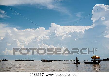 Members of a floating village along the shores of Tonle Sap lake in Cambodia, head out into open water to fish; Siem Reap, Cambodia View Large Photo Image Stock Photo - Members of a floating village along the shores of Tonle Sap lake in Cambodia, head out into open water to fish; Siem Reap, Cambodia. Fotosearch