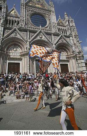 Stock Image - Members of neighbourhood districts, dressed in medieval clothing, perform traditional flag throwing in front of Siena Cathedral. Siena, Tuscany. Italy., Siena, Tuscany. Italy.. Fotosearch