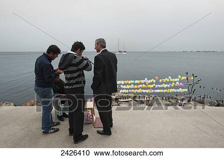 Stock Image - Men at a shooting target at the water's edge; Istanbul, Turkey. Fotosearch