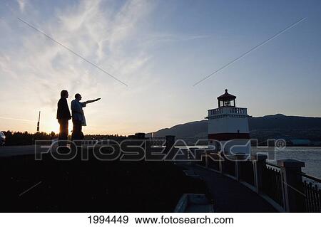 Men By The Lighthouse At Brockton Point In Stanley Park, Vancouver At Sunset, British Columbia, Canada View Large Photo Image Stock Photo - Men By The Lighthouse At Brockton Point In Stanley Park, Vancouver At Sunset, British Columbia, Canada. Fotosearch