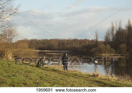 Stock Image - Men Fishing On The Shores Of Lake Ulemiste, Tallinn, Estonia. Fotosearch