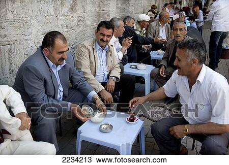 Men gather and drink tea around the walls of Fatih Mosque the boundary of the Carsamba Pazari, the Wednesday Market in Fatih. This is one of Istanbul's oldest and most colourful market places in Istanbul, Turkey. View Large Photo Image Stock Image - Men gather and drink tea around the walls of Fatih Mosque the boundary of the Carsamba Pazari, the Wednesday Market in Fatih. This is one of Istanbul's oldest and most colourful market places in Istanbul, Turkey.. Fotosearch