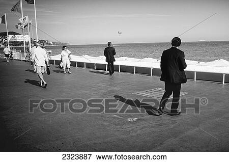 Men in black business suits on a seaside promenade; Nice, France View Large Photo Image Stock Photo - Men in black business suits on a seaside promenade; Nice, France. Fotosearch