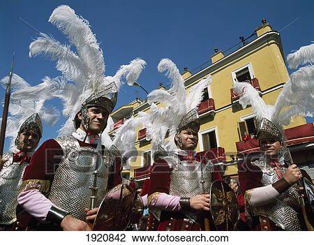 Stock Image - Men In Roman Soldier Costumes In Semana Santa Parade Through Seville, Andalucia, Spain. Fotosearch