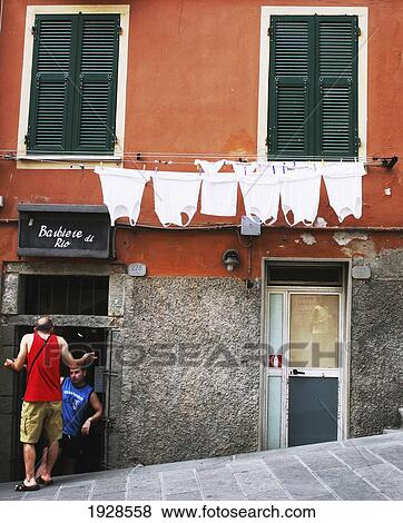 Stock Photo - Men Outside Barber Shop; Manarola, Cinque Terre, Italy. Fotosearch