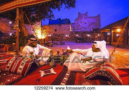 Picture - Men relaxing at dusk; Asir Province, Saudi Arabia. Fotosearch