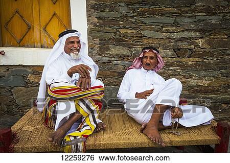 Stock Photograph - Men relaxing, near Rijal Alma village; Asir Province, Saudi Arabia. Fotosearch