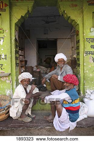 Stock Image - Men Sitting Outside House. Fotosearch