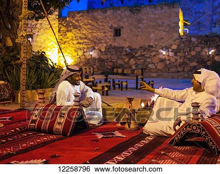 Stock Photograph - Men sitting, relaxing and talking; Abha, Saudi Arabia. Fotosearch