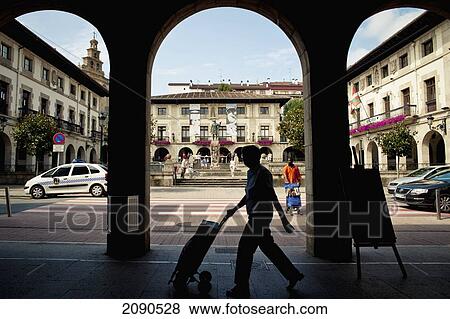 Stock Photo - Men Walking In Front Of Don Tello Statue And Culture House In Plaza De Los Fueros, Gernika-Lumo, Basque Country, Spain. Fotosearch