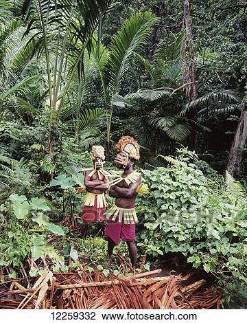 Stock Image - Men wearing the traditional Malangaan masks of New Ireland; New Ireland, Papua New Guinea. Fotosearch