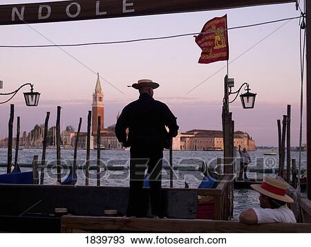 Stock Image - Men With Gondola's, San Giorgio Maggiore; Venice, Italy. Fotosearch