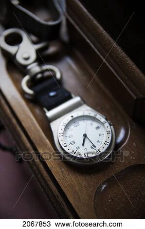 Stock Image - Metal Pocket Watch On Wooden Tray, Maricourt, Quebec. Fotosearch