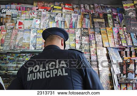 Stock Image - Mexico, Aguascalientes state, Aguascalientes, Policeman at magazine stand. Fotosearch