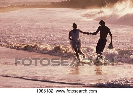 Mexico, Cabo San Lucas, Couple Playing In Ocean Waves At Sunset. View Large Photo Image Stock Image - Mexico, Cabo San Lucas, Couple Playing In Ocean Waves At Sunset.. Fotosearch