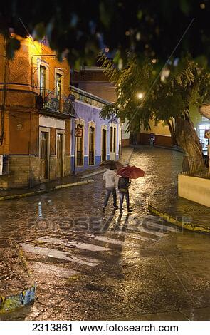 Mexico, Guanajuato, Guanajuato, People walking with umbrellas on rainy evening View Large Photo Image Stock Image - Mexico, Guanajuato, Guanajuato, People walking with umbrellas on rainy evening. Fotosearch