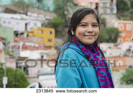 Stock Photography - Mexico, Guanajuato, Portrait of girl in front of suburbs houses. Fotosearch