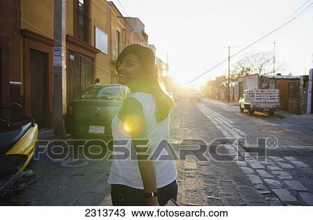 Mexico, Guanajuato, San Miguel de Allende, Portrait of Woman walking down cobblestone street with sun flare in shot View Large Photo Image Stock Image - Mexico, Guanajuato, San Miguel de Allende, Portrait of Woman walking down cobblestone street with sun flare in shot. Fotosearch