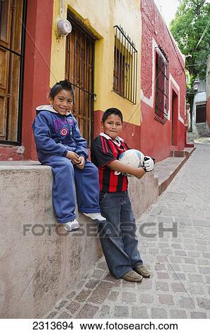 Picture - Mexico, Guanajuato State, Guanajuato, Portrait of Two young boys with soccer ball in alley of old Spanish town. Fotosearch